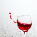 In a tilted glass splashing red wine Royalty Free Stock Photo