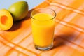 tilted shot of mango juice on a colorful tabletop