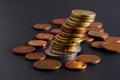 Tilted stack of coins close-up on a blurred dark background