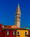 Tilted tower over red and yellow houses on the island of Burano