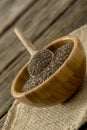 Tilted view of small wooden bowl full of chia seeds