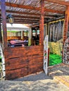 Timber bar stools and table sitting on the sand beside a set of stairs leading to a beachfront restaurant