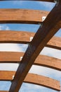 Timber frame arch against blue sky midday underneath view. Royalty Free Stock Photo