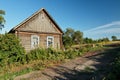 Timber house in Russian countryside near unsurfaced road Royalty Free Stock Photo