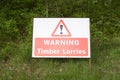 Timber lorries trucks wagons warning sign on road forest woodlands beware danger tree felling Royalty Free Stock Photo