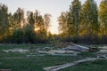 Timber lying on the meadow in the countryside. In the background - spring forest Royalty Free Stock Photo