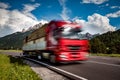 Timber truck rushes down the highway in the background the Alps. Truck Car in motion blur Royalty Free Stock Photo