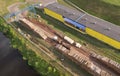 Timber truck unloading a cut trees in at woodworking plant. Transportation raw timber from felling site. Gantry crane loads logs Royalty Free Stock Photo