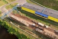 Timber truck unloading a cut trees in at woodworking plant. Transportation raw timber from felling site. Gantry crane loads logs