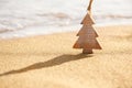 Timber wooden Christmas tree on a sand on the tropical beach near ocean, summer Christmas and winter holyday concept Royalty Free Stock Photo