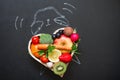 Time alarm on diet and healthy lifestyle concept with fruits and vegetables and clock on blackboard