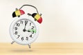 Time change in Belgium, spring forward. Summer time concept, over white background. A white alarm clock with a minute Royalty Free Stock Photo