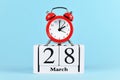 Time change for daylight saving summer time in Europe on March 28th concept with red alarm clock and calendar Royalty Free Stock Photo