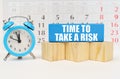 Against the background of the calendar, an alarm clock and a blue block with the inscription - Time to Take a Risk Royalty Free Stock Photo