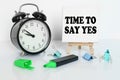 On the table is an alarm clock, a marker and a tripod with a canvas with the inscription - TIME TO SAY YES Royalty Free Stock Photo