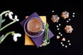 Time for a cup of hot coffee: a cup of coffee and a bouquet of snowdrops on a stack of books, gingerbread, two heart-shaped sugar Royalty Free Stock Photo