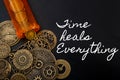 Time cures everything or time heals every pain concept with a bottle of prescription painkiller bottle and small metallic clock