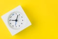 Time, deadline or reminder and schedule concept, minimal modern square alarm clock with white face on yellow background in flat