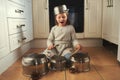 Time for a drumroll. a little girl playing drums on a set of pots in the kitchen. Royalty Free Stock Photo