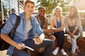 Time for exam prep with my peers. Portrait of a student studying outside on campus with his classmates.