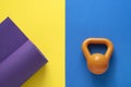 Time for exercising sport equipment concept with yoga mat and kettlebell on color table background Royalty Free Stock Photo