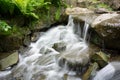 Time exposure photo shot with a small waterfall over rocks in a stream and milky blurred water Royalty Free Stock Photo