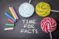 TIME FOR FACTS. Text and candy on a dark board