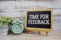 Time For Feedback text written on blackboard with alarm clock on wooden background Royalty Free Stock Photo