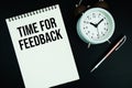 Time For Feedback text written on notepad with pen and alarm clock Royalty Free Stock Photo