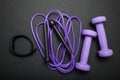 Time for fitness. Sports accessories on a black background. Jump rope, dumbbells and fitness bracelet