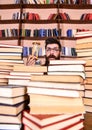 Time flow concept. Man on surprised face holds hourglass while studying, bookshelves on background. Teacher or student Royalty Free Stock Photo