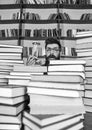 Time flow concept. Man on surprised face holds hourglass while studying, bookshelves on background. Teacher or student Royalty Free Stock Photo