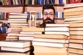 Time flow concept. Teacher or student with beard studying in library. Man, scientist in glasses looks at hourglass. Man Royalty Free Stock Photo