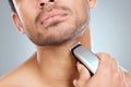 Time for a fresh look. a man shaving his beard with an electric razor. Royalty Free Stock Photo