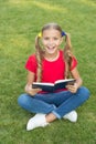 Time for great stories. Little child reading book outdoors. Schoolgirl read stories while relaxing green lawn. Cute