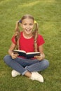 Time for great stories. Little child reading book outdoors. Schoolgirl read stories while relaxing green lawn. Cute