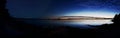 Time laps panorama: Lake with a sunset on the right and the night star sky on the left Royalty Free Stock Photo