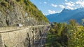 Time lapse, car and train traffic on the road next to the bare mountain rock. Morschach, canton of Schwyz, Switzerland