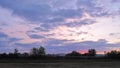 Time lapse HD1080p . Moving clouds at sunset over rural buildings in the field.
