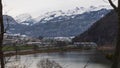 Time lapse panoramic view on town in swiss Alps with snowy mountains at the background. Lake Lauer. Seewen, Canton Schwyz,