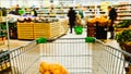 Time-lapse speed shopping trolley rides to the supermarket and filled with food, shelving and blurred buyers Royalty Free Stock Photo