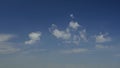 Time-lapse of white clouds passing by in blue sky over field of golden wheat