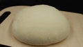 Time lapse. Yeast dough increases in size. The dough on the cutting board rises on black background