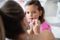 Mother helping her little girl with make up Royalty Free Stock Photo