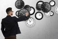 Time management concept. Businessman and different clocks on light grey background Royalty Free Stock Photo