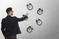 Time management concept. Businessman stretching hand to falling alarm clocks on light background Royalty Free Stock Photo