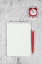 Time management concept. To-do list: red alarm clock, pencil and notebook Royalty Free Stock Photo