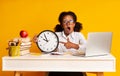 Elementary Student Girl Pointing Finger At Clock Sitting At Laptop Royalty Free Stock Photo