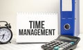 time management words on white notebook with clock, calculator and paper folder Royalty Free Stock Photo