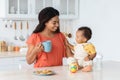 Time With Mom. Cute Black Baby Boy Relaxing With Mother In Kitchen Royalty Free Stock Photo